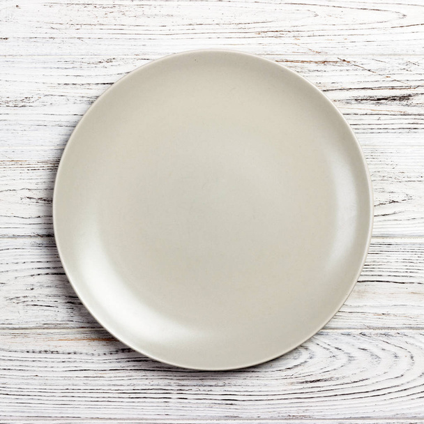 Top view with empty for you design. Empty white plate on wooden background - Foto, Bild