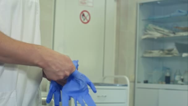 Cirujano que se pone guantes de goma estériles para operación quirúrgica
 - Metraje, vídeo