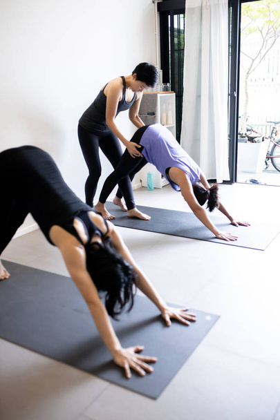 junge Frau praktiziert Yoga im grauen Hintergrund.  - Foto, Bild