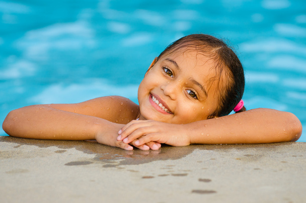 Portrait of happy pretty mixed race child by side of pool during summer - Foto, imagen