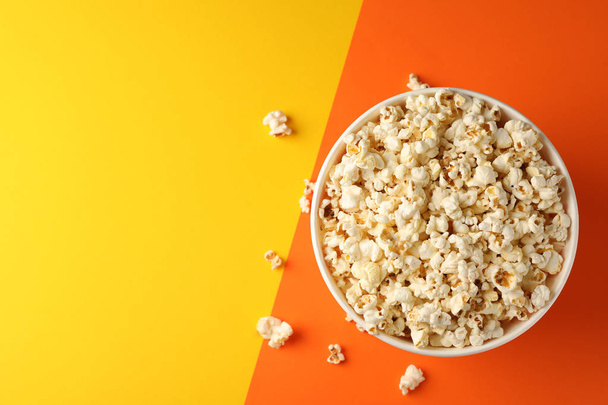 Flat lay composition. Bucket with popcorn on two tone background - Photo, Image