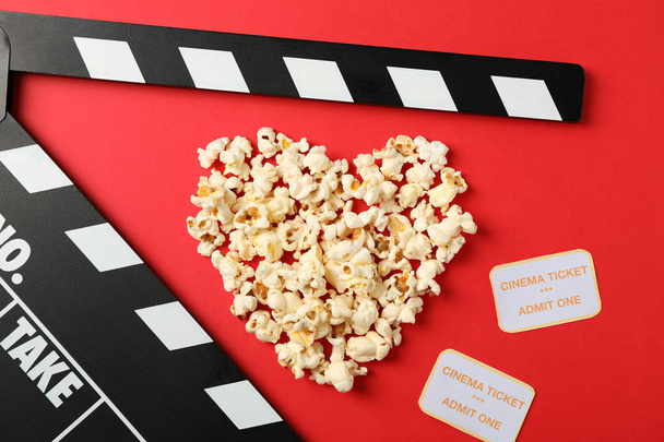 Herz aus Popcorn, Klappbrett und Karten auf rotem Bac - Foto, Bild