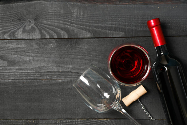 Επίπεδη σύνθεση με μπουκάλι κρασί, γυαλιά και τιρμπουσόν  - Φωτογραφία, εικόνα