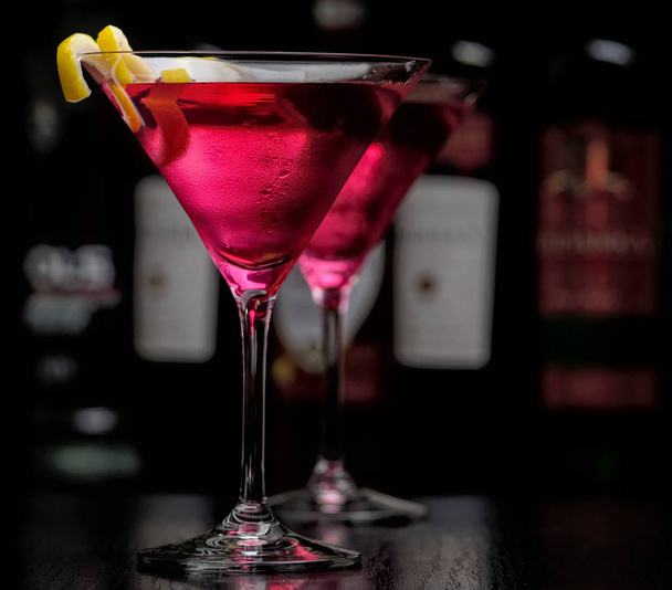 Two cosmopolitan cocktails in bar on black - Fotó, kép