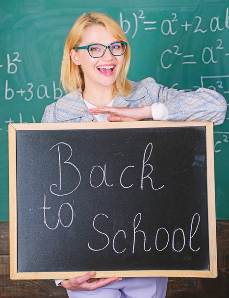 Top ways to welcome students back to school. Teacher woman hold blackboard inscription back to school. It is school time again. School teacher glad to welcome pupils. Great beginning of school year - Foto, Bild