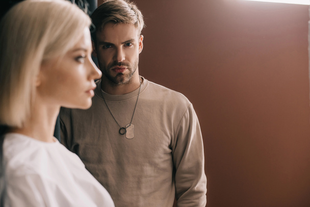 selective focus of attractive blonde girl and bearded young man on brown - Fotografie, Obrázek