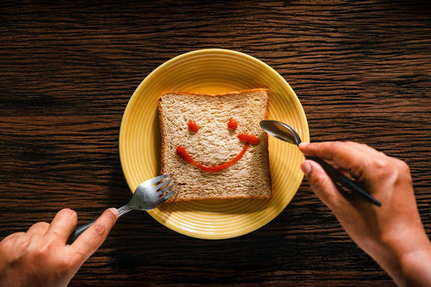 Concetto Happy Life. Giovane persona che mangia pane nel tempo della colazione
. - Foto, immagini