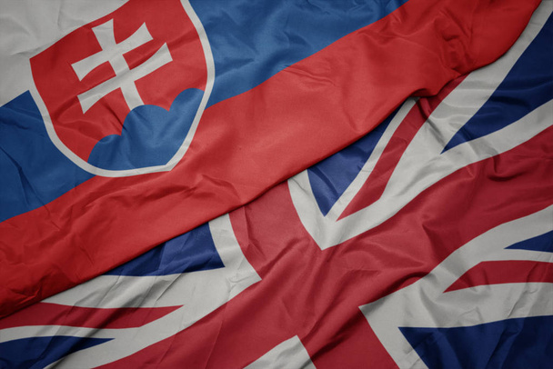 ondeando colorida bandera de Gran Bretaña y bandera nacional de Eslovaquia
. - Foto, imagen