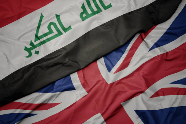 agitant le drapeau coloré de la Grande Bretagne et le drapeau national de l'Irak
. - Photo, image