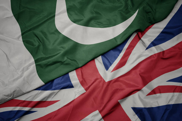 falujące kolorowe flagi Wielkiej Brytanii i flagi narodowej Pakistanu. - Zdjęcie, obraz