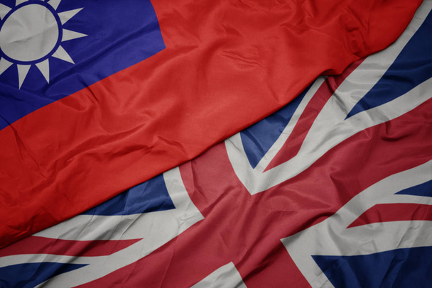 ondeando colorida bandera de Gran Bretaña y bandera nacional de Taiwán
. - Foto, imagen