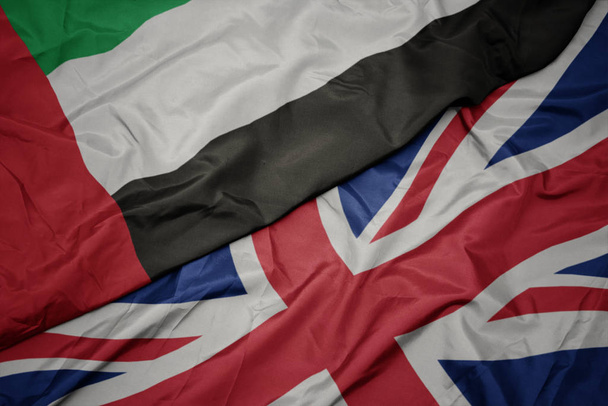 acenando bandeira colorida de grande britânico e bandeira nacional de emirados árabes unidos
. - Foto, Imagem