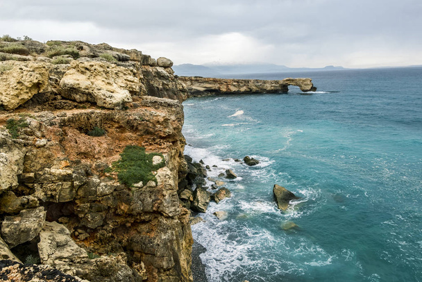 Rock in the form of a stone arch on the coast of Crete in the Me - Photo, image