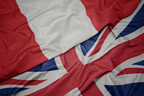 integetett színes zászló Nagy-Britannia és a nemzeti zászló Peru. - Fotó, kép