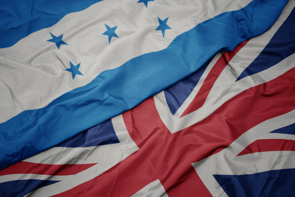 integetett színes zászlója Nagy-Britannia és a nemzeti zászló Honduras. - Fotó, kép