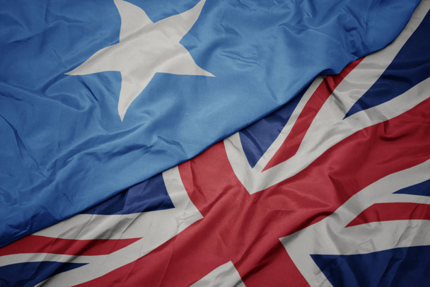 waving colorful flag of great britain and national flag of somalia. - Photo, Image