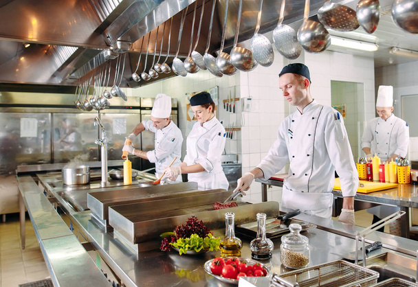 Cocina moderna. Los cocineros preparan comidas en la estufa en la cocina del restaurante u hotel. El fuego en la cocina. - Foto, Imagen