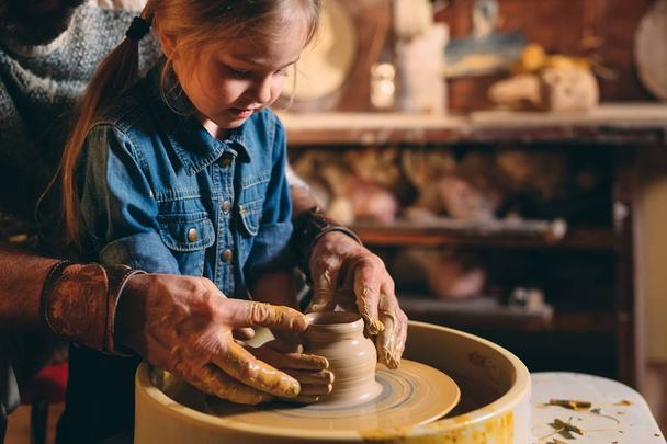 Pottery workshop. Grandpa teaches granddaughter pottery. Clay modeling - Fotoğraf, Görsel