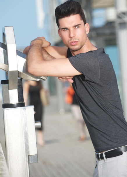 Male fashion model leaning on telescope outdoors - Foto, Bild