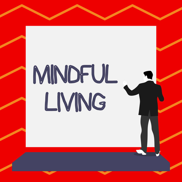 Słowo pisanie tekstu Mindful Living. Koncepcja biznesowa w pełni świadomy i zaangażowany w coś świadome i sensowne krótkie włosy niedojrzały młody człowiek stoją przed prostokąt duży blank Board. - Zdjęcie, obraz