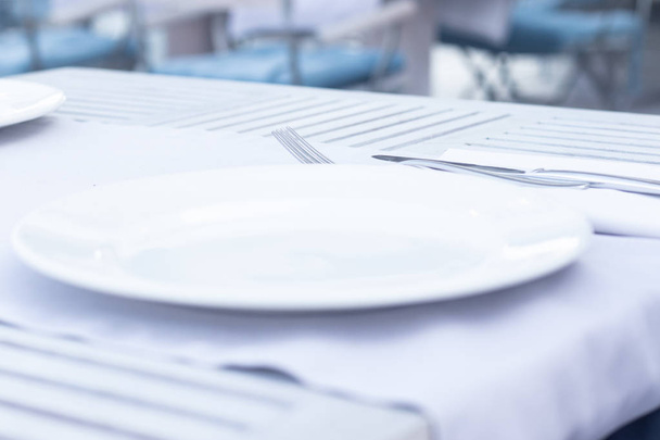 White plate on blurred bakground. Wooden table in restraunt. - Foto, Imagen