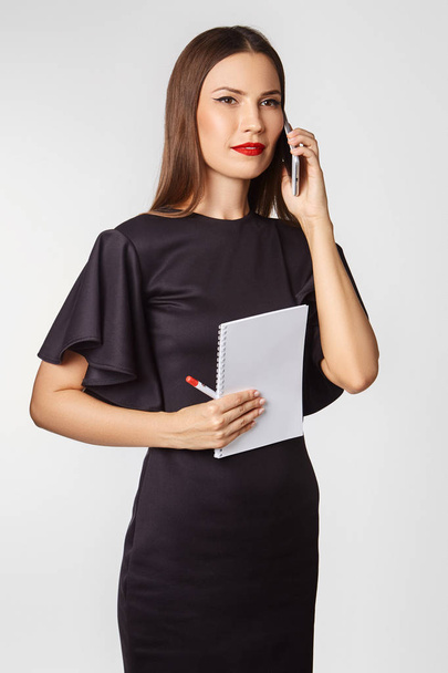 Attractive brunette in a business style in the studio on a white background - Valokuva, kuva