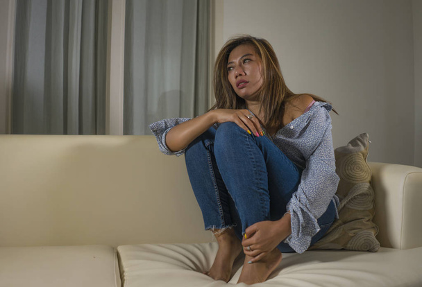 young beautiful sad and depressed woman thoughtful and confused at home couch feeling broken heart suffering depression crisis and anxiety problem - Foto, Imagen