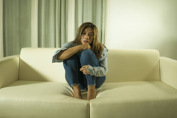 young beautiful sad and depressed woman thoughtful and confused at home couch feeling broken heart suffering depression crisis and anxiety problem - Foto, Bild