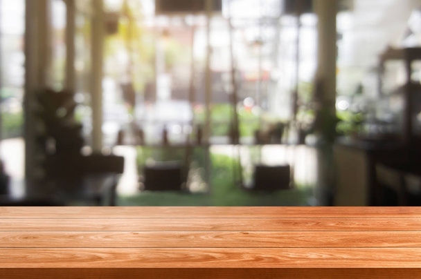 Wooden table in blurry background of modern restaurant room or coffee shop with copy space. - Photo, Image