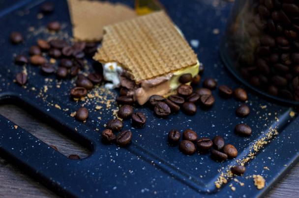 Cut of vanilla, chocolate and cream ice cream next to waffles and coffee beans. - Фото, зображення