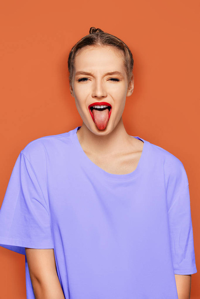 Chica divertida con pecas pintadas mostrando la lengua
 - Foto, Imagen