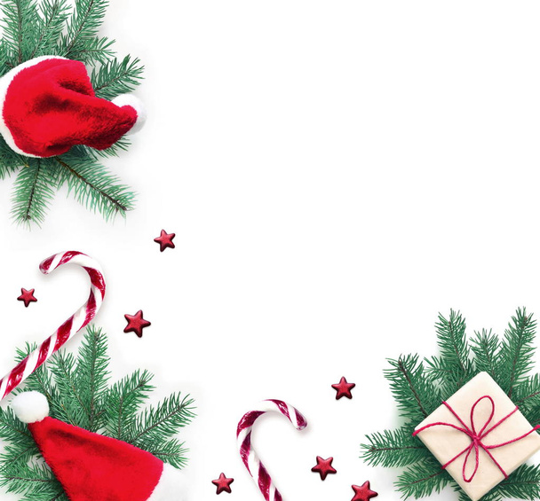Karácsonyi kompozíció. Ajándék, fenyő, karácsonyi kalap és édes mankó fehér alapon. Karácsony, tél, újévi koncepció. Lapos feküdt, felülnézet. - Fotó, kép