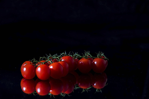 Sweet fresh tomatoes on a black background, close up, macro, still life photography - Φωτογραφία, εικόνα