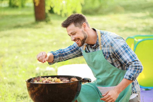 Άνθρωπος μαγείρεμα νόστιμο φαγητό σε μπάρμπεκιου ψησταριά σε εξωτερικούς χώρους - Φωτογραφία, εικόνα