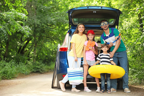 Gelukkige familie in de buurt van auto voorbereid op reizen - Foto, afbeelding