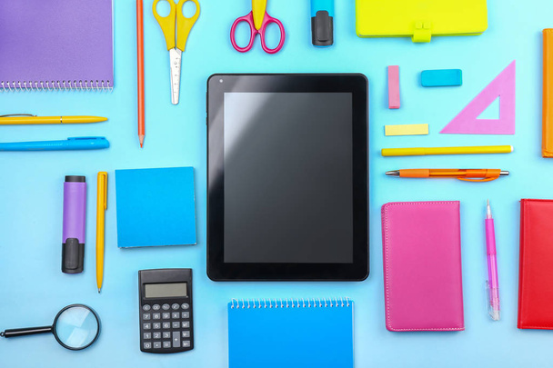 Tablet computer and stationery on color background - Foto, Imagen