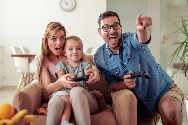 Familia feliz jugar videojuegos juntos en casa. - Foto, Imagen