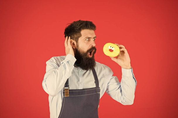 No way. True facts about sugar. Hipster bearded baker hold glazed donut on red background. Cafe and bakery concept. Sweet donut from baker. Man bearded baker in cooking apron hold cute dessert - Fotografie, Obrázek