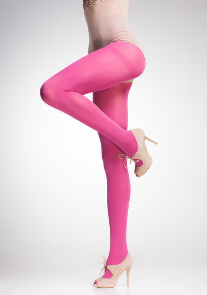 roze kousen op sexy vrouw benen geïsoleerd op grijs - Foto, afbeelding