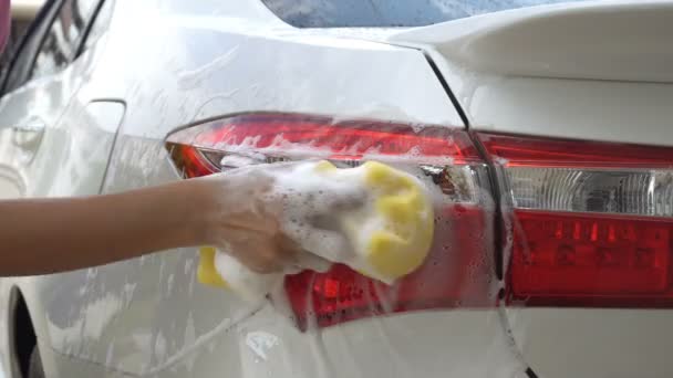 黄色い泡スポンジ洗濯車テールライトで女性の手をクローズアップ。コンセプト自動車サービス、洗車 - 映像、動画