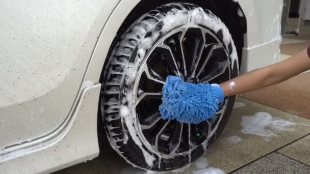 Primer plano de la mano de la mujer con tela de microfibra azul lavado de coches Neumáticos y ruedas. Concepto Auto Car Service, lavado de coches
 - Metraje, vídeo