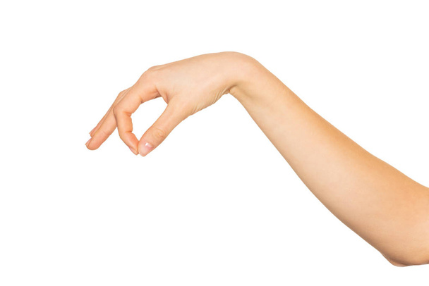 Prázdná ženská ruka držela něco mezi palcem a ukazováčkem, izolovaná na bílém - Fotografie, Obrázek