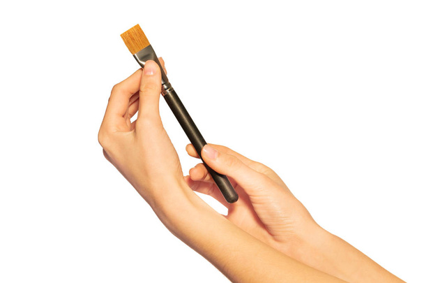 Close-up picture of large shader brush in hands of make-up artist isolated on white background - 写真・画像