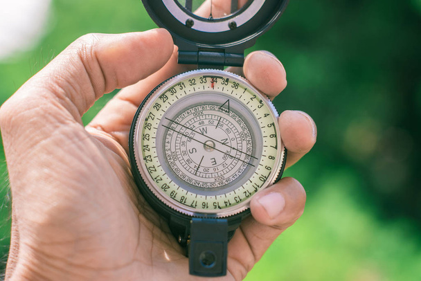 holding compass on blurred background. Using wallpaper or backgr - Photo, image