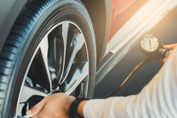 Asiatique homme voiture inspection Mesurer la quantité gonflé pneus en caoutchouc  - Photo, image