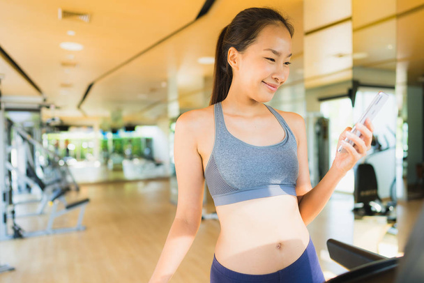 Portrait beautiful asian young woman using mobile phone in gym - Foto, immagini