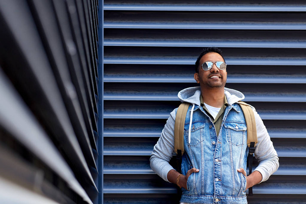 smiling indian man with backpack on city street - Fotografie, Obrázek