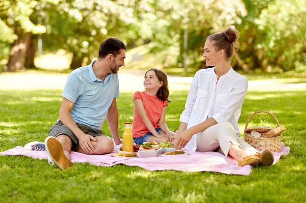 happy family having picnic at summer park - Foto, Imagen
