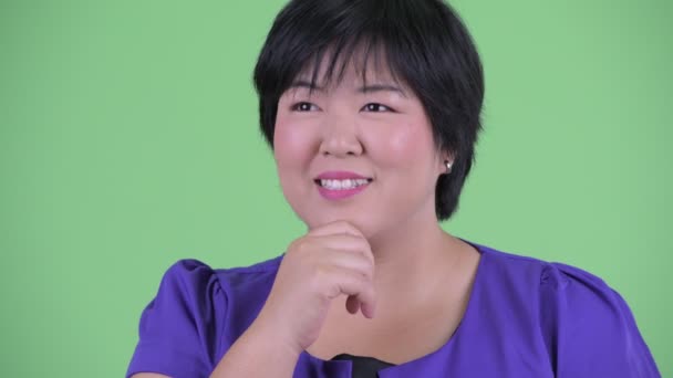 Face of happy young beautiful overweight Asian woman thinking and looking up - Felvétel, videó