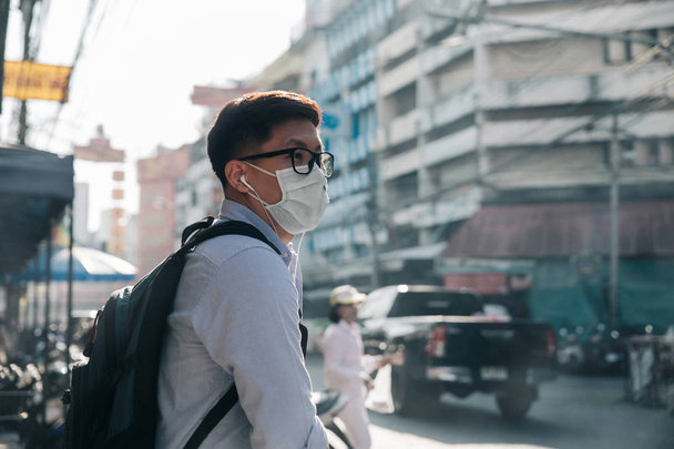 Homem asiático a usar uma máscara na rua. Protecção contra o ar p
 - Foto, Imagem